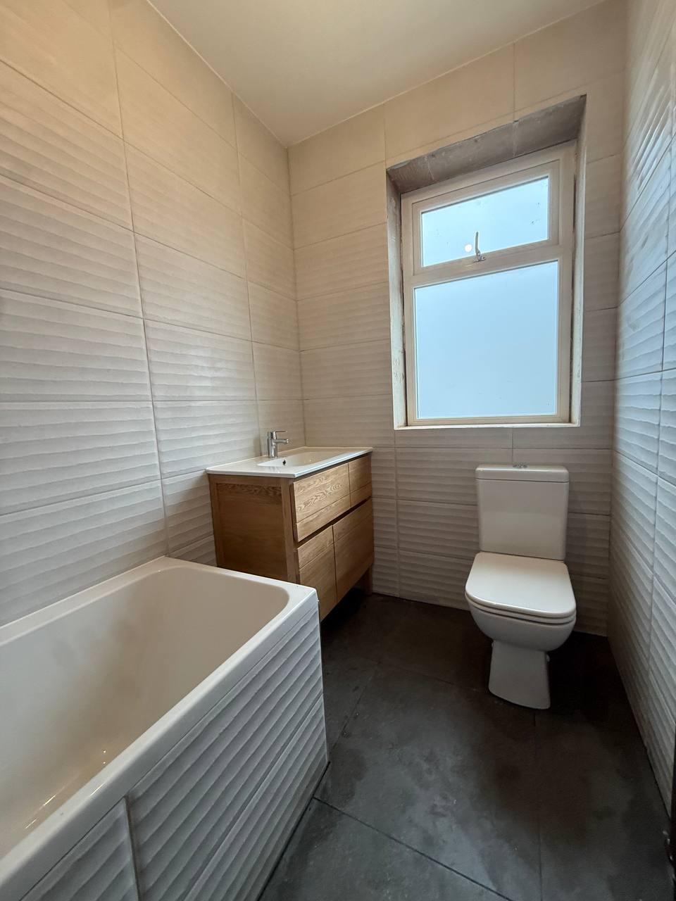 Bathroom after renovation Glasgow - new tiles, bath and vanity unit