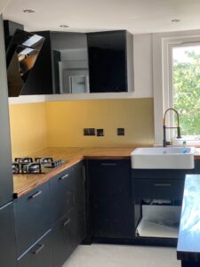 Navy kitchen with Belfast sink and yellow splashback — Glasgow renovation