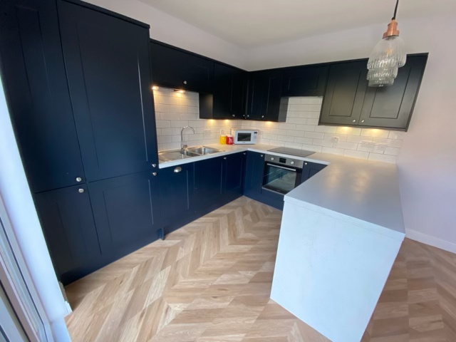 L-shape navy shaker kitchen Clarkston with chevron flooring and white worktops